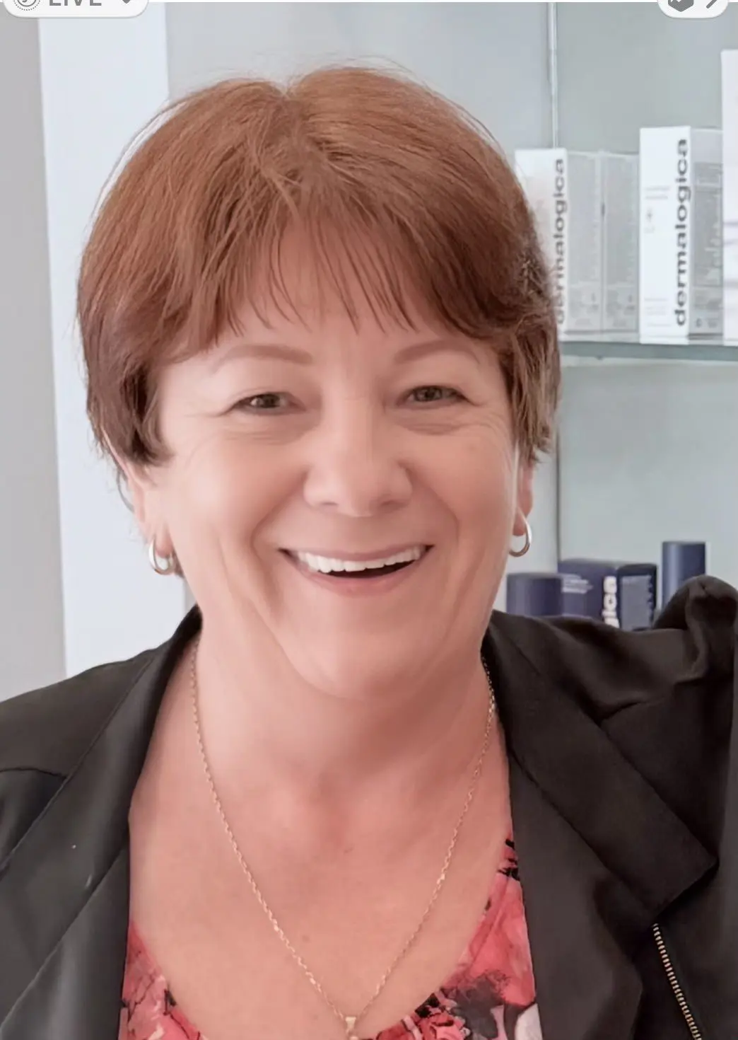 Smiling woman with short auburn hair in an office setting.