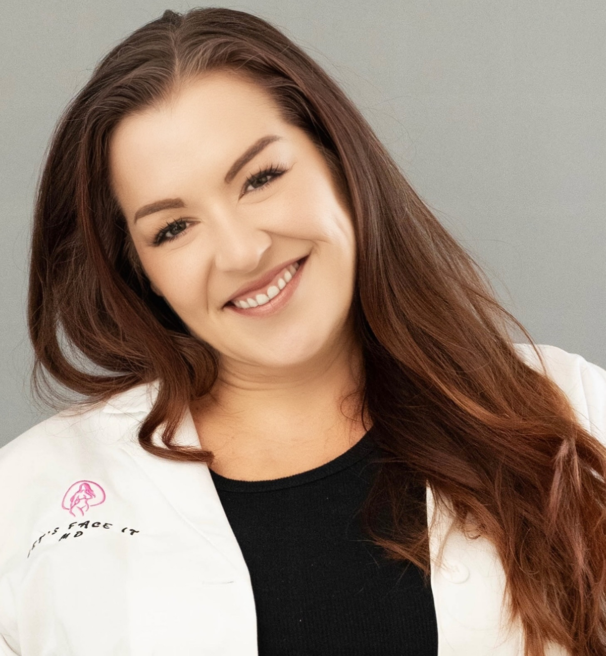 Smiling woman in a white coat, likely a healthcare professional.